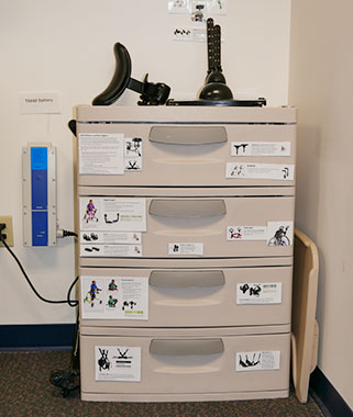 A close up of the cabinets used by the MOVE team at Langan school to organize their adaptive equipment.