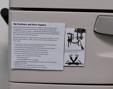 A close-up of an adaptive equipment storage drawer with a description of equipment that stores in it.