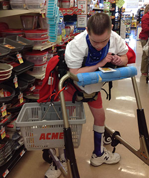A young man uses the Pacer gait trainer in special education to go shopping at the local store.