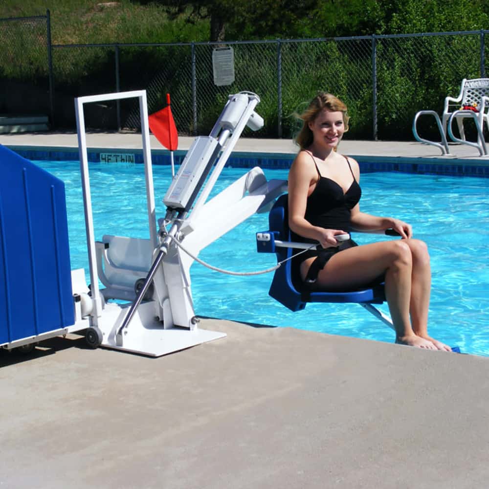 Woman entering a pool with the aid of a handicap pool lift