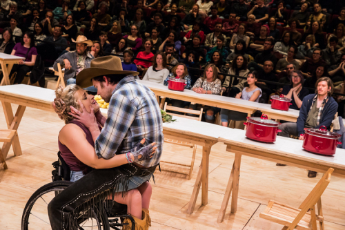 Ali Stroker with man in plaid shirt and cowboy shirt straddling her lap during a performance of Oklahoma! for which she was nominated for a Tony Award