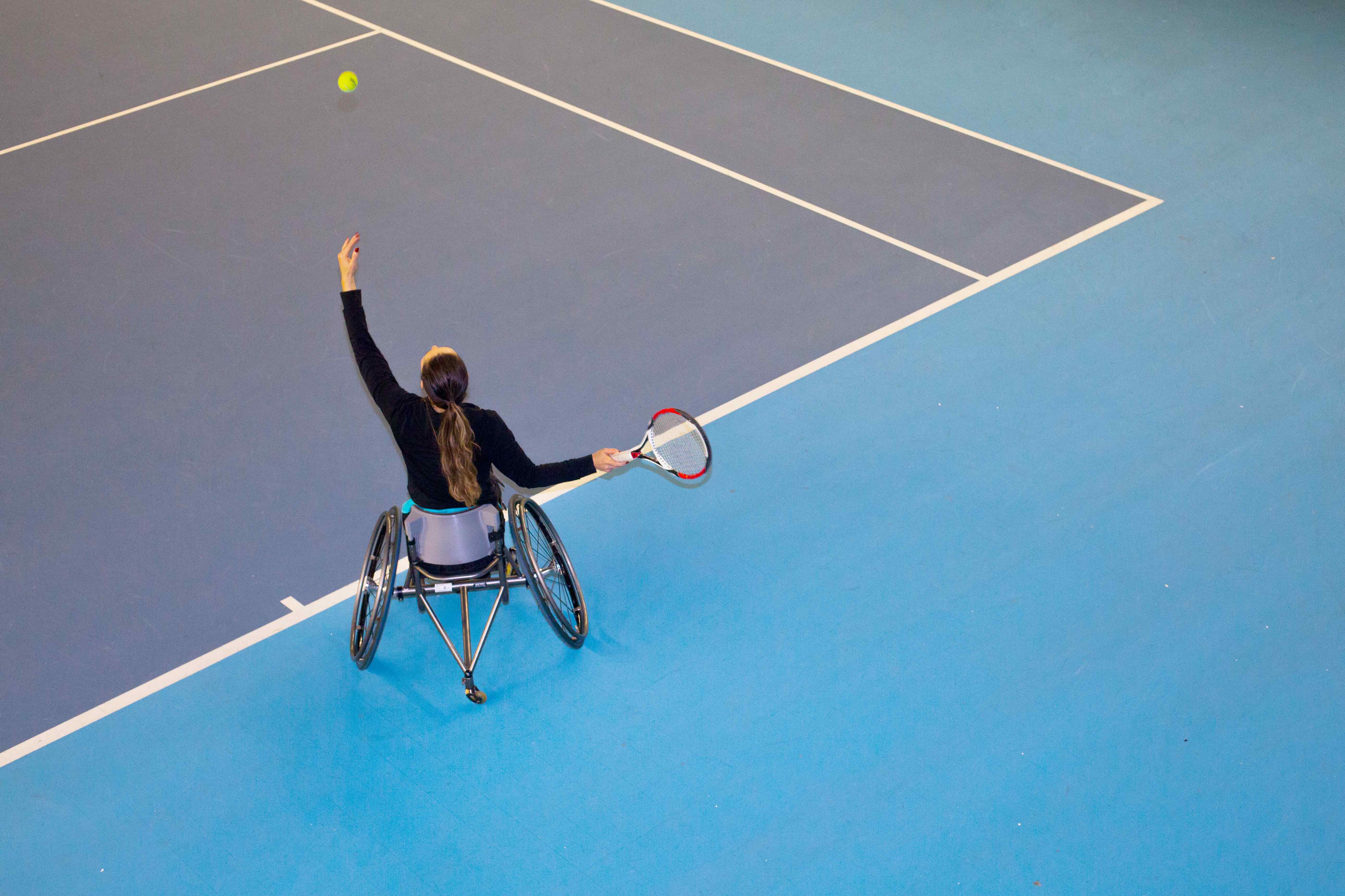 A woman in a wheelchair in the middle of a tennis serve, the kind of photos Getty is hoping to spur with its disability photography grant