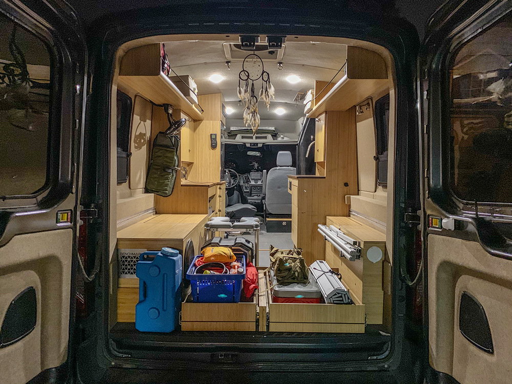 Everything has a home when living the #vanlife. From tools to tables and stoves and medical supplies, it’s important to stay organized. This is the area beneath the bed that’s used to set up the outside kitchen when staying in one place for a few days. Notice the ceiling fan for ventilation.